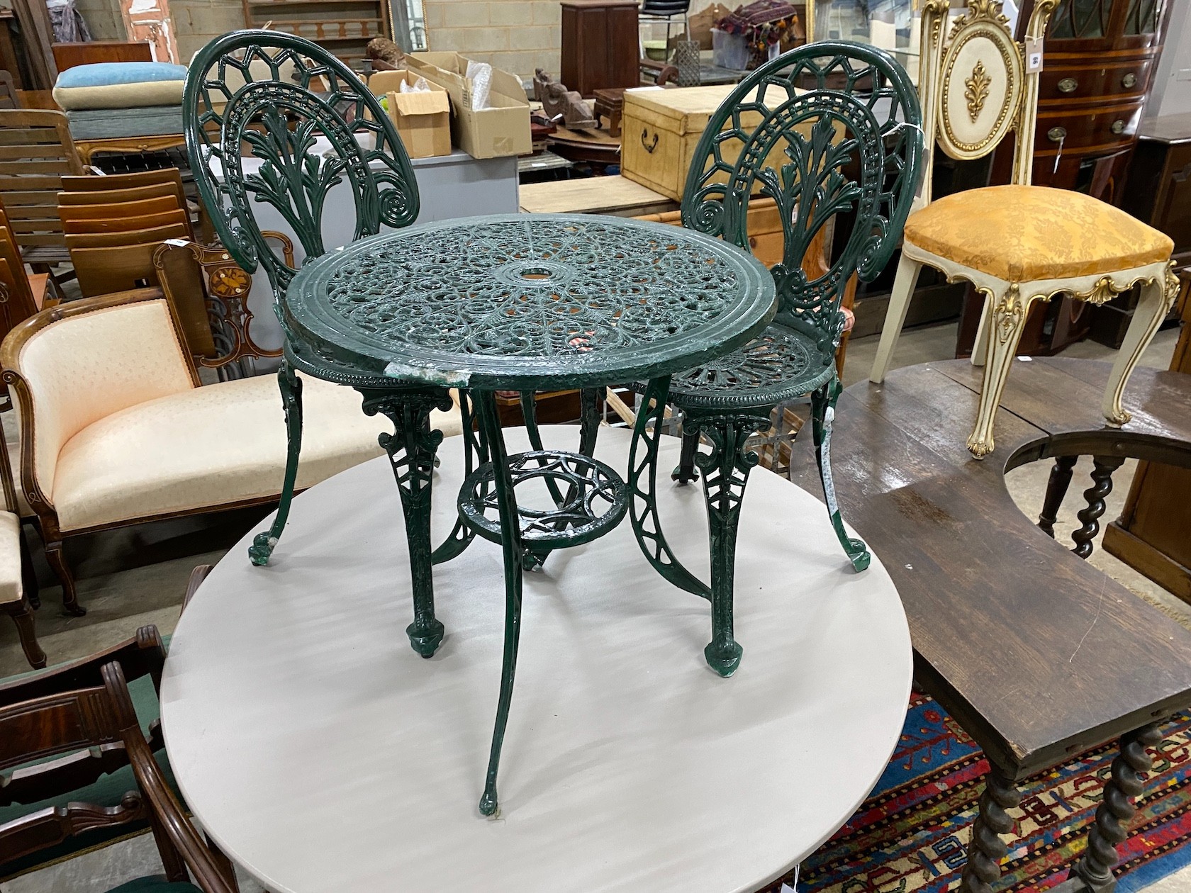 A Victorian style aluminium garden table, diameter 60cm, height 62cm and two chairs